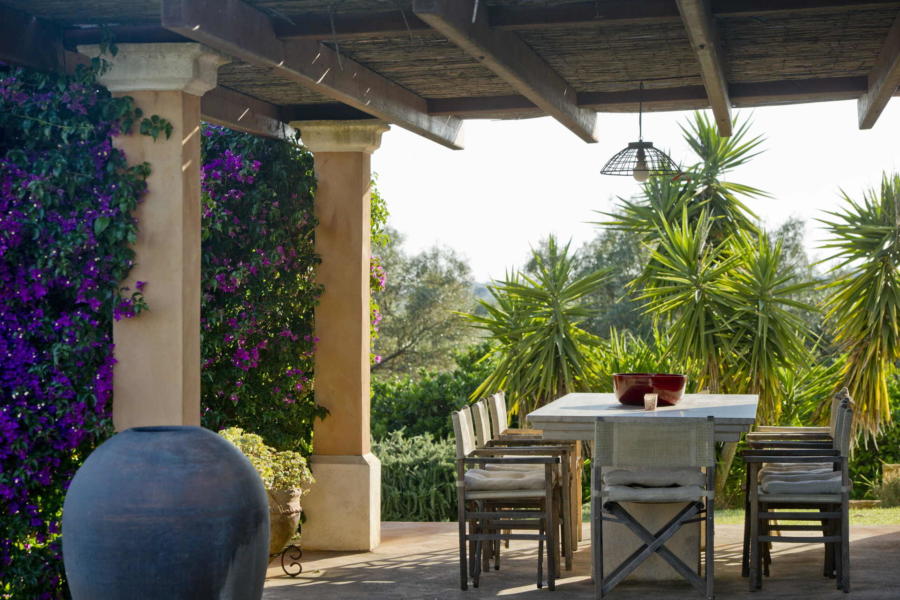 Lunch in the patio with a view of the pool surrounded by greenery in Villa Bouganville Castelvetrano Scent of Sicily