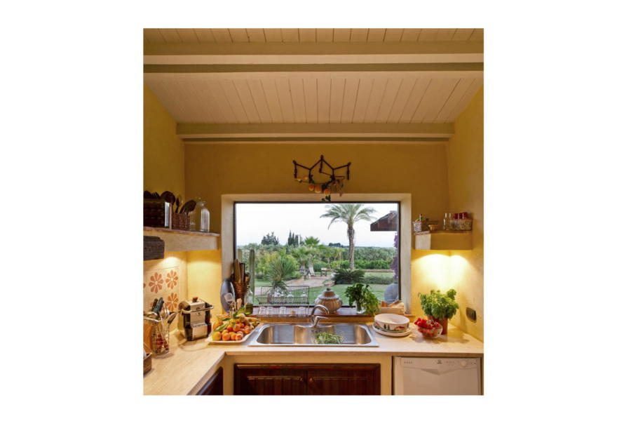 The view of the beautiful garden from the equipped kitchen in Villa Bouganville Castelvetrano Scent of Sicily