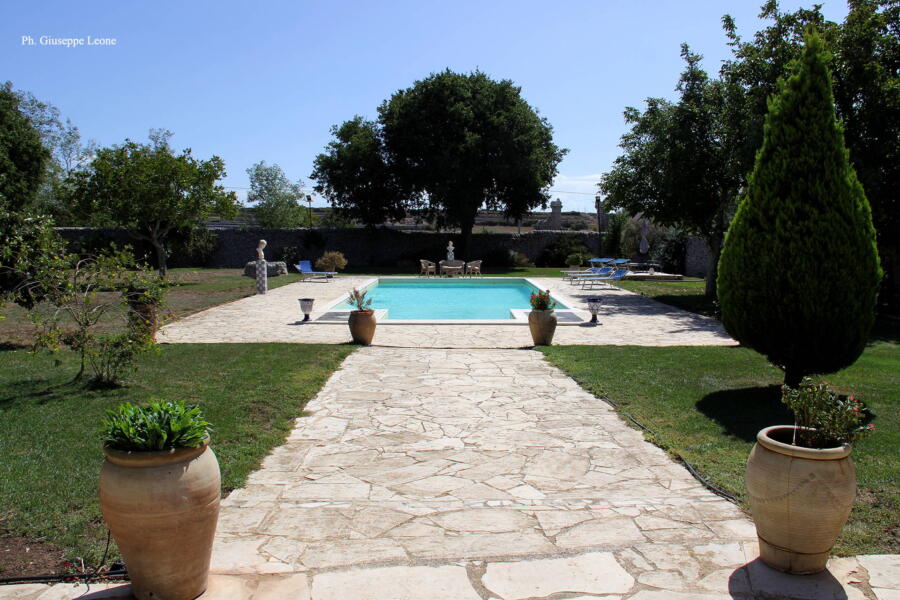The greenery of this charming historic residence surrounds the swimming pool.