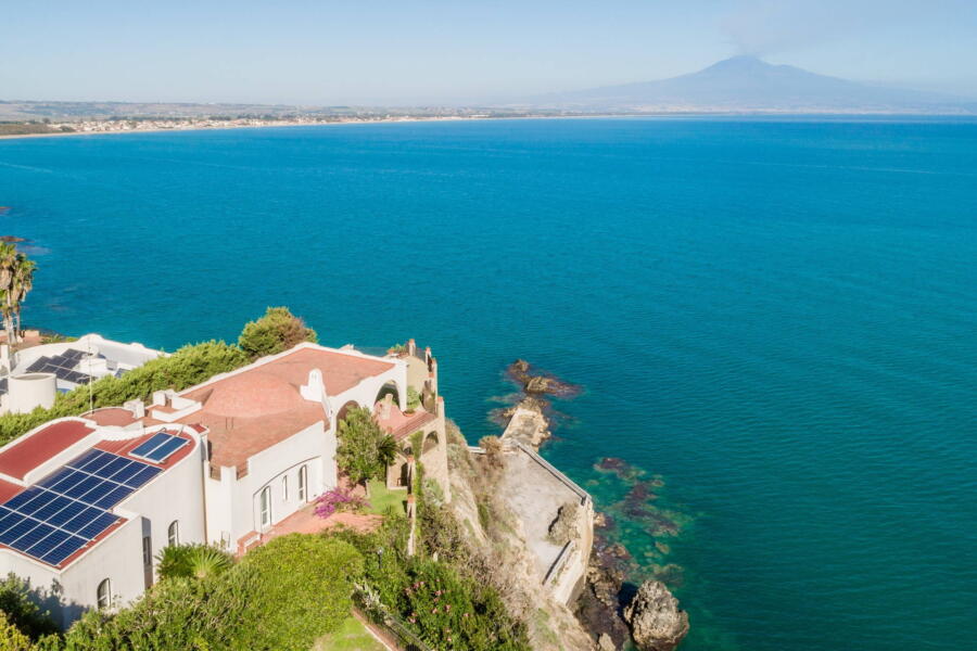 The view of the blue sea with the volcano Etna behind it