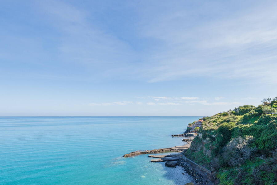 The blue sea below the residence which is accessed by a private road, an area which only residents of the residence can access.