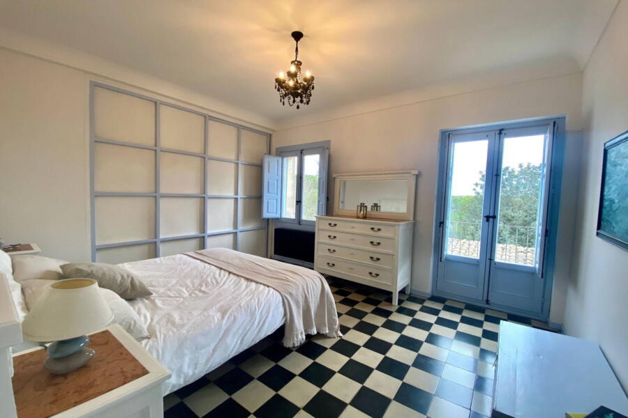 The bedroom on the first floor where blue and white are the predominant colours with a chequered floor.