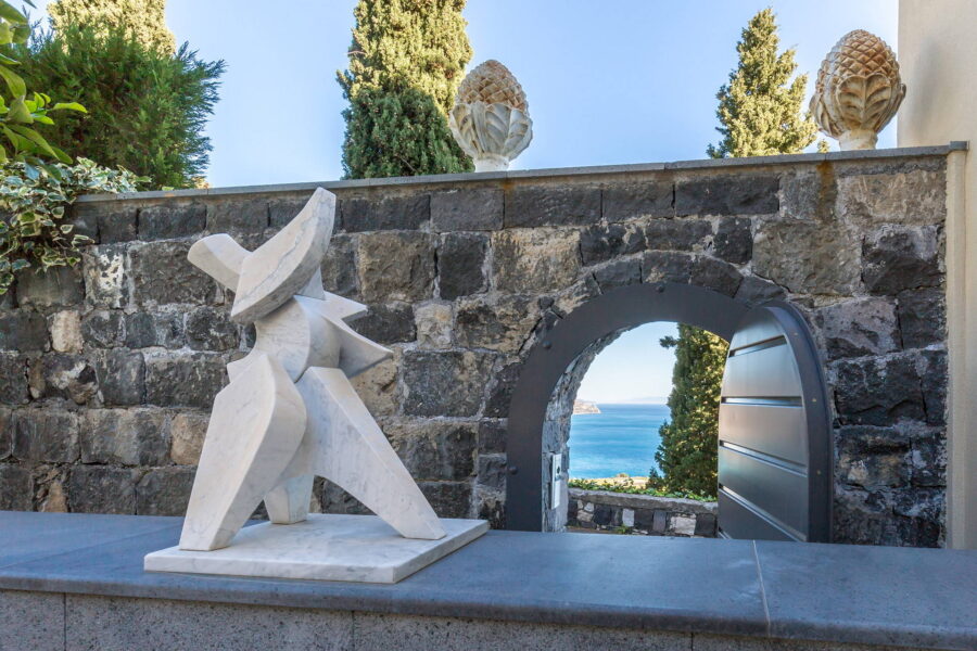 Exterior view of Villa Arte in Taormina, Sicily, surrounded by lush greenery and overlooking the sea.