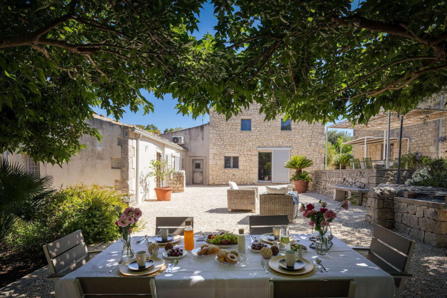 Courtyard of a villa with a pool in Sicilian Baroque colors - Luxury villa in Sicily.