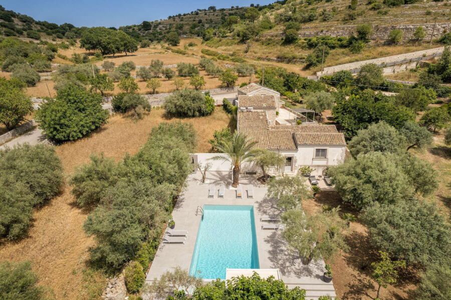 Aerial view of a Sicilian villa with pool surrounded by Baroque colors.