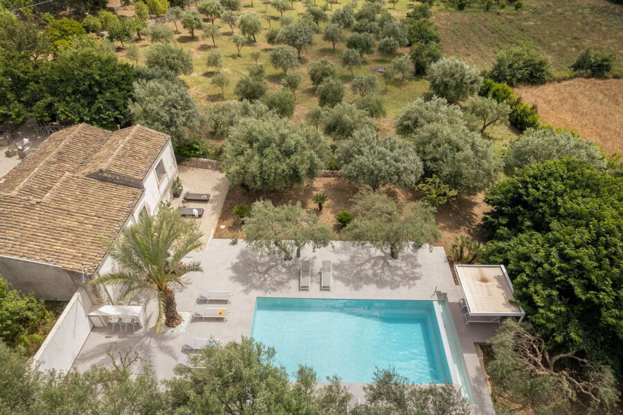 Aerial view of this pool villa villa in Sicilian Baroque, surrounded by greenery and featuring a sparkling pool
