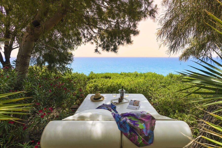 A picturesque view of a coastal cottage in Menfi, Sicily, with a breathtaking view of the Mediterranean Sea, accentuated by clear blue skies.