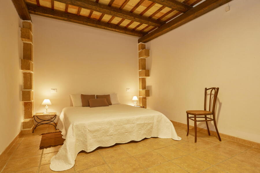 Warm and welcoming guest bedroom with traditional Sicilian architecture.