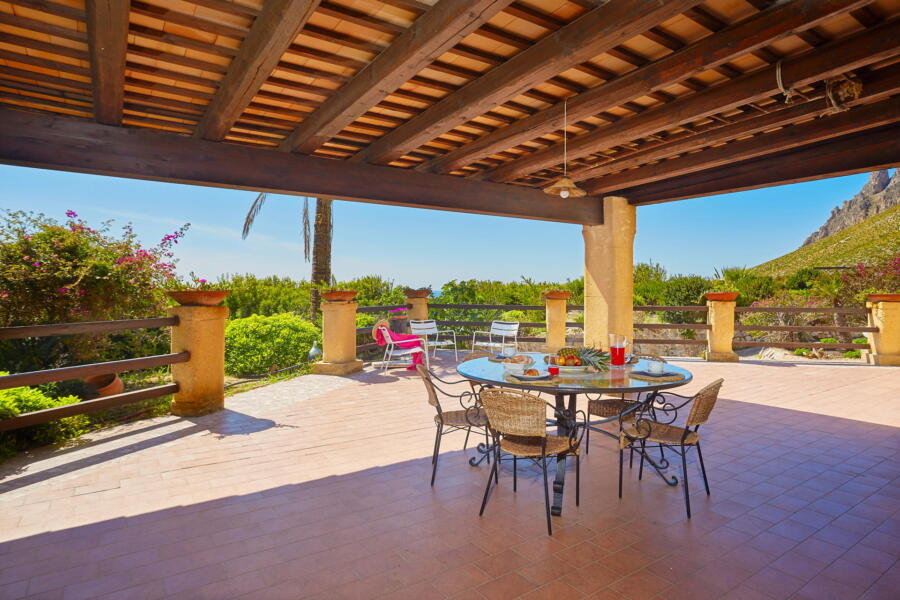 "Outdoor dining area with a view of Sicilian hills at Villa Nature's Embrace.
