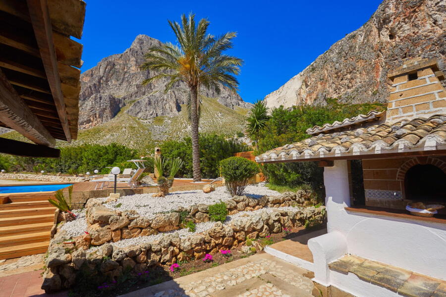 A rustic stone BBQ area near the pool at a luxury villa in Sicily.