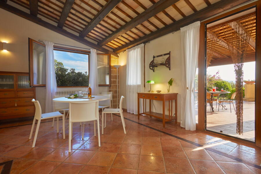 Dining area with open doors leading to the terrace at Villa Nature's Embrace.