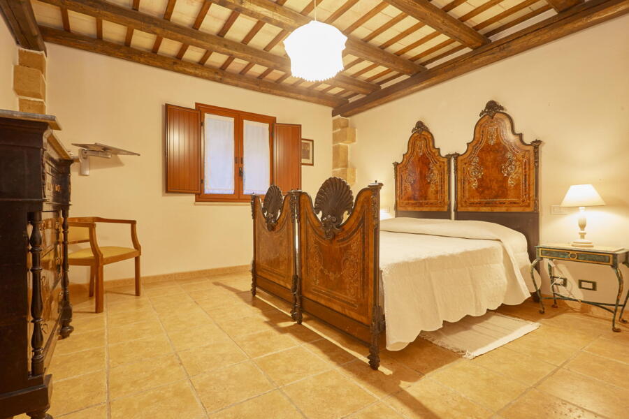 Antique wooden bedframe in a spacious bedroom at Villa Nature's Embrace.
