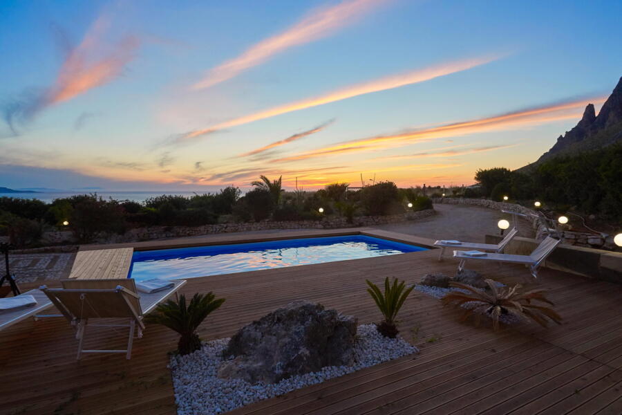Poolside loungers under a sunset sky at Villa Nature's Embrace.