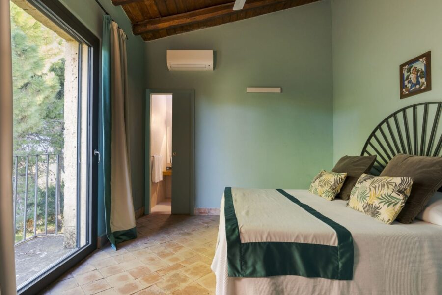 Peaceful bedroom with en-suite and garden view at Villa Selvira, a top-rated Sicily luxury villa with pool.