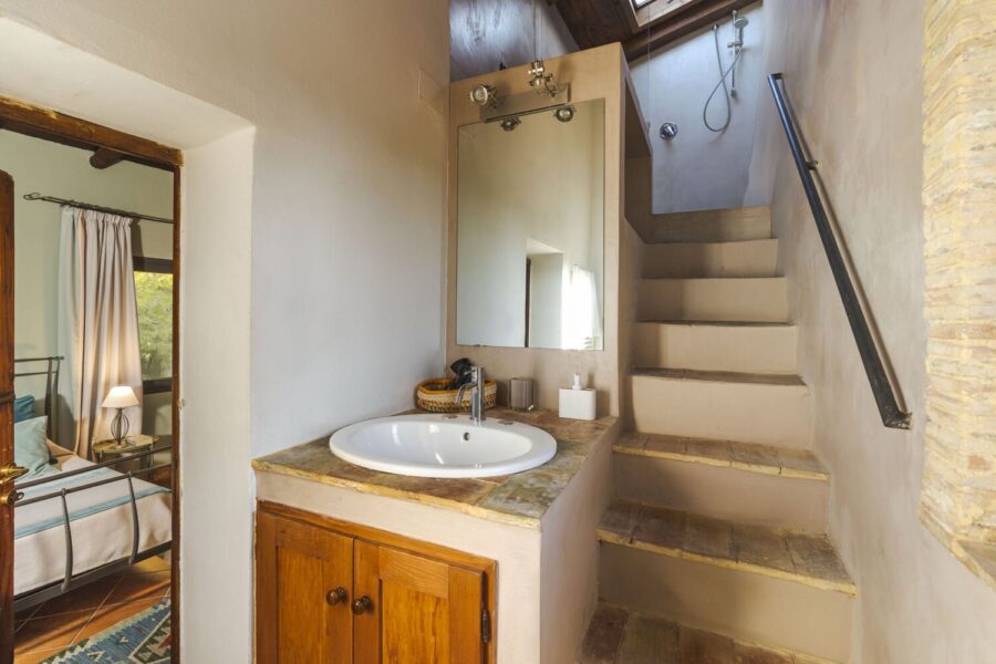 En-suite bathroom in Villa Selvira, a Sicily luxury villa, featuring stone stairs leading to an upper-level shower.
