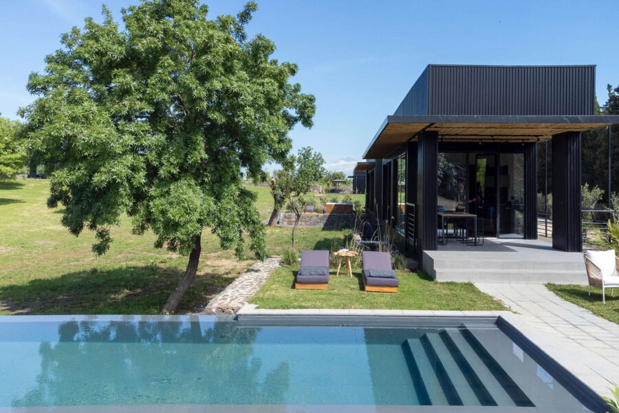 Contemporary black villa with shaded patio and sun loungers facing a private pool at Nature Luxe Cottage, Sicily.