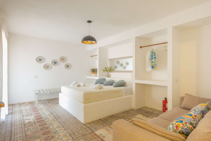Spacious double bedroom at Villa Brezza Marina in Scopello with traditional Sicilian tiled floor, ceramic wall décor, soft neutral furnishings and elegant design – Sicily Luxury Villas and Sicily villas with pool