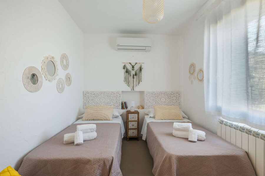 Twin bedroom at Villa Brezza Marina in Scopello with two single beds, handcrafted wall décor and soft neutral furnishings – Sicily Luxury Villas and Sicily villas with pool