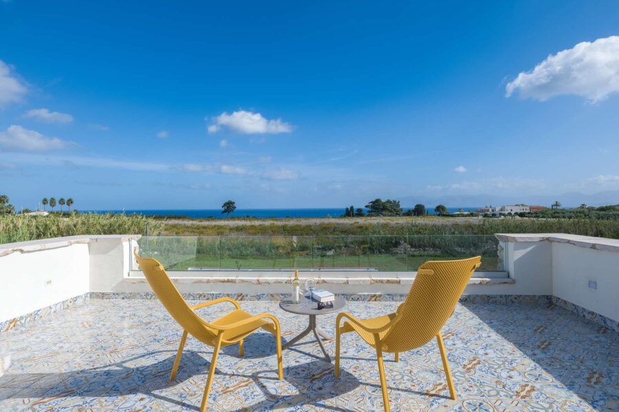 Panoramic terrace at Villa Brezza Marina in Scopello with Sicilian tiled floor, yellow chairs and open sea view – Sicily Luxury Villas and Sicily villas with pool
