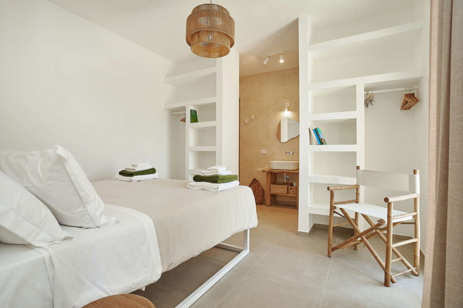 Sicily Luxury Villas – stylish bedroom with ensuite bathroom, natural decor and soft lighting in Sicily villa with pool in Castellammare del Golfo