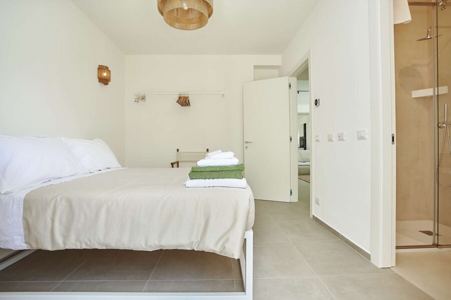 Minimalist bedroom in Sicily Luxury Villas with double bed, neutral tones, ensuite bathroom and modern design at Villa White Horizon, Sicily villas with pool
