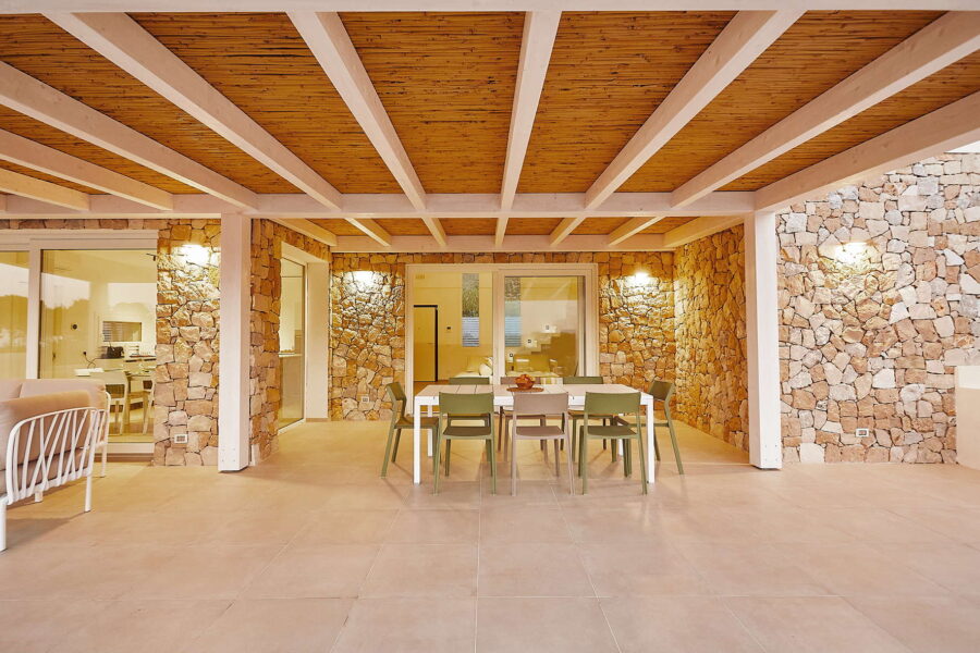 Covered outdoor patio with dining table, stone walls and wooden ceiling in Sicily Luxury Villas – Villa White Horizon, Sicily villas with pool