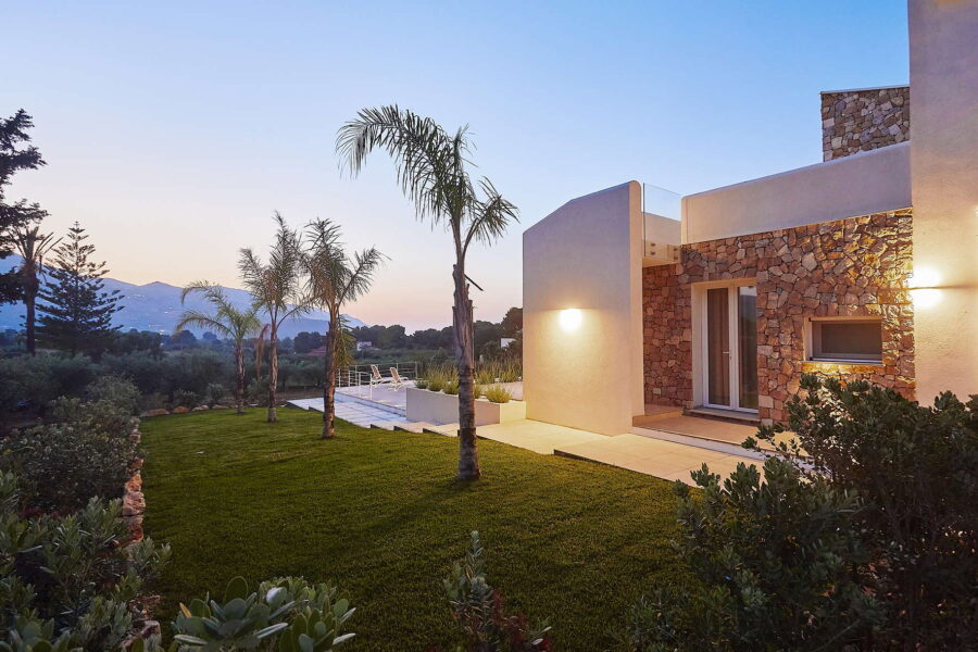 Sicily Luxury Villas with pool – modern villa at sunset with garden, palm trees and outdoor lounge at Villa White Horizon in Castellammare del Golfo