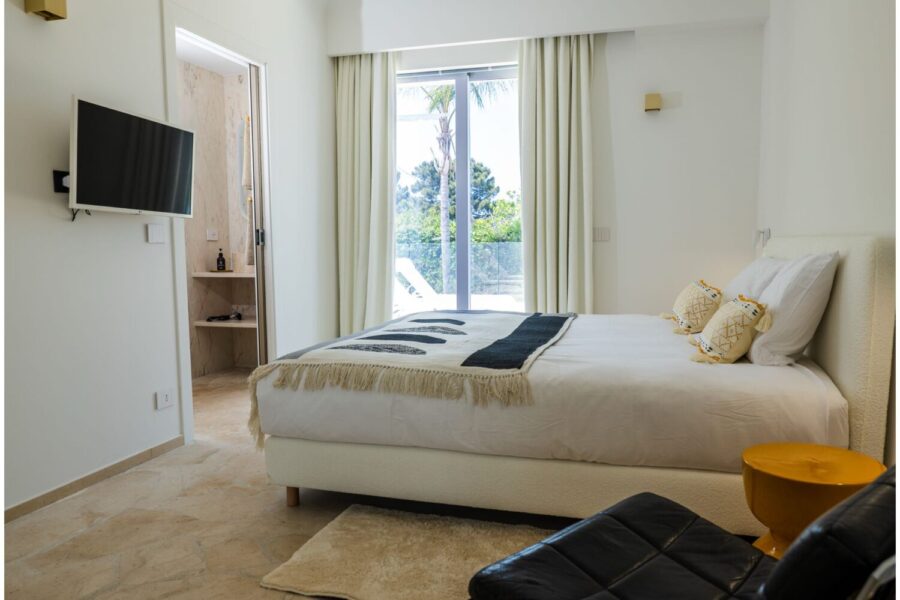 VillaOrlaya-Capo-di-Orlando-DoubleBedroomEnSuite-Black&White-ScentOfSicily Elegant double bedroom suite at Villa Orlaya with modern interiors, en suite bathroom, and garden views in one of the finest Sicily villas with pool.