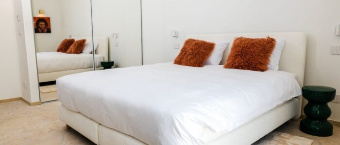 Modern double bedroom with mirrored wardrobe and elegant décor at Villa Orlaya, one of the stylish Sicily villas with pool and contemporary interiors.