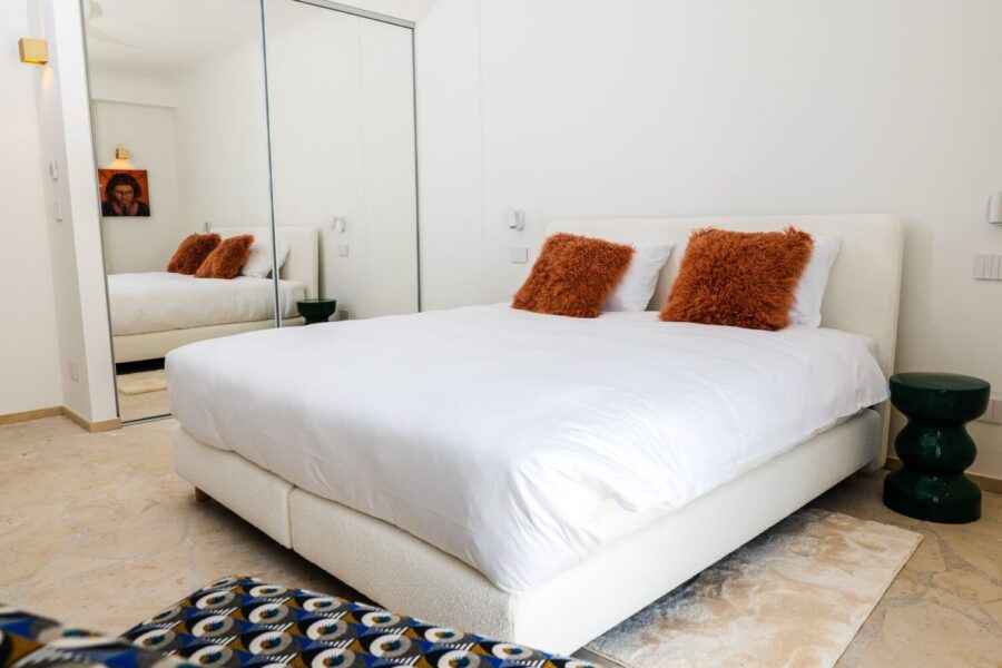 VillaOrlaya-Capo-di-Orlando-DoubleBedroomEnSuiteOrange-ScentOfSicily Modern double bedroom with mirrored wardrobe and elegant décor at Villa Orlaya, one of the stylish Sicily villas with pool and contemporary interiors.