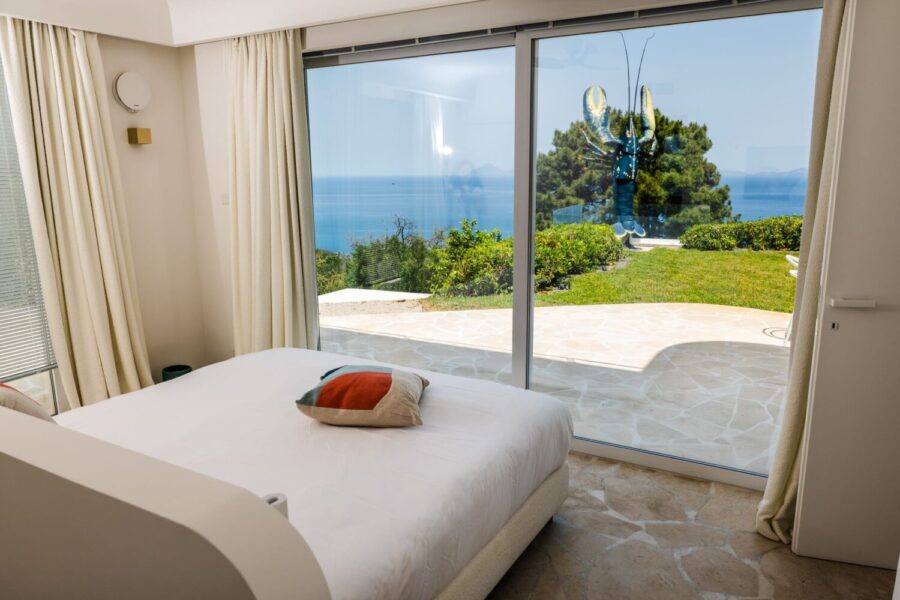 VillaOrlaya-Capo-di-Orlando-DoubleBedroomEnSuiteSeaView-jpgScentOfSicily Modern double bedroom with sea view terrace at Villa Orlaya, one of the Sicily villas with pool featuring elegant interiors and panoramic coastal views in Sicily.
