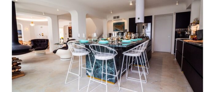 Modern open kitchen and dining area at Villa Orlaya, a stylish Sicily villa with pool featuring marble finishes, contemporary interiors, and spacious living areas.