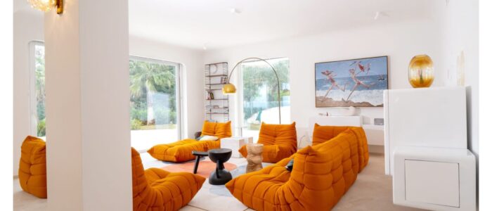 Contemporary orange living room at Villa Orlaya, a luxury Sicily villa with pool featuring designer seating, modern décor, and bright open interiors.