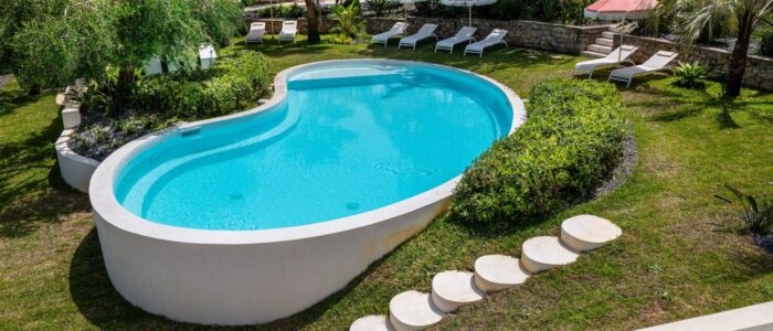 Aerial view of Villa Orlaya private swimming pool surrounded by tropical gardens and sun loungers in Sicily, Sicily villas with pool by Scent of Sicily