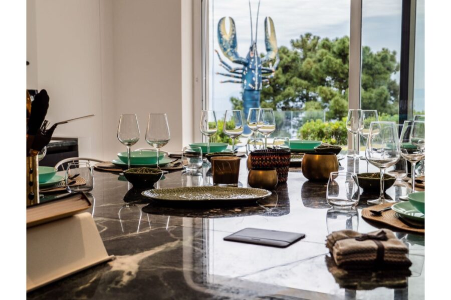 VillaOrlaya-Capo-di-Orlando-TableView-ScentOfSicily Stylish dining table with sea view at Villa Orlaya, a contemporary Sicily villa with pool featuring elegant interiors and panoramic coastal scenery.