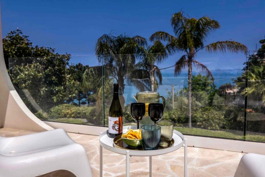 VillaOrlaya-Capo-di-Orlando-TerraceView-ScentOfSicily Sea view terrace at Villa Orlaya with wine, outdoor seating, and tropical garden views, Sicily villas with pool by Scent of Sicily